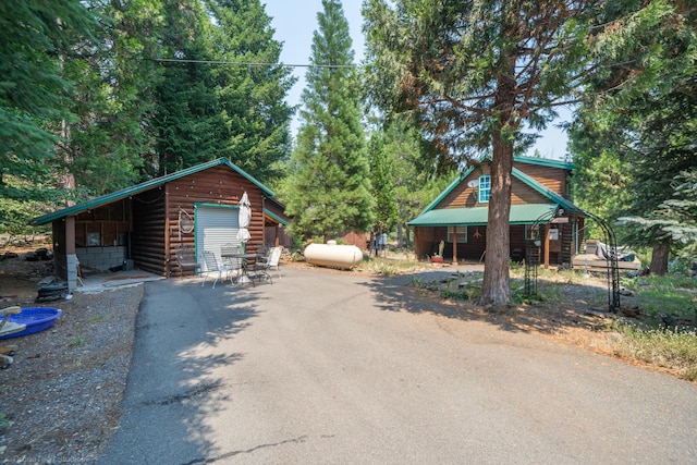 view of front of home with a garage, metal roof, and driveway