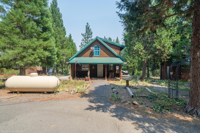 chalet / cabin with a porch and metal roof