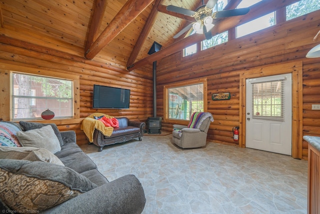 living room featuring ceiling fan, wooden ceiling, beam ceiling, stone floors, and a wood stove