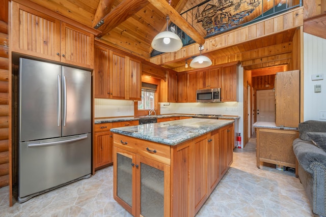 kitchen with stainless steel appliances, a kitchen island, light stone countertops, and brown cabinets