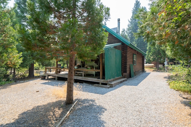 view of property exterior featuring a deck and log siding