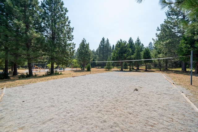 surrounding community with driveway and volleyball court