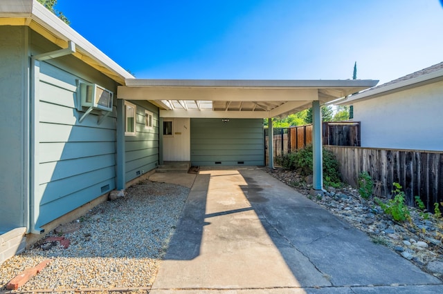 view of car parking with a carport, an AC wall unit, and fence