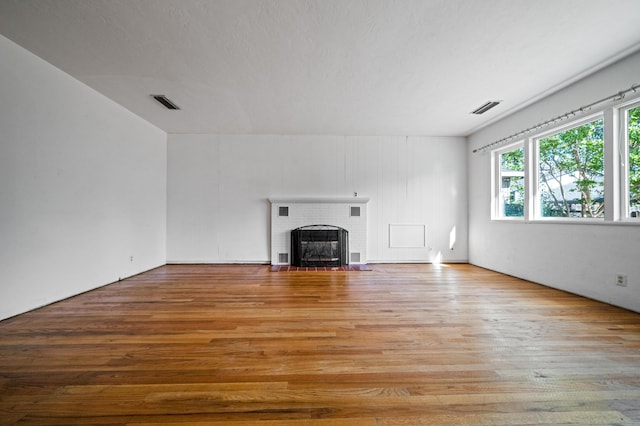 unfurnished living room with a fireplace and light hardwood / wood-style flooring