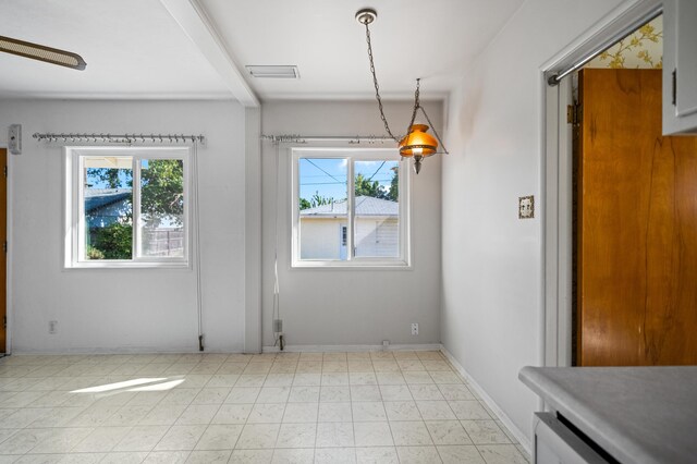 empty room featuring light tile patterned floors and plenty of natural light