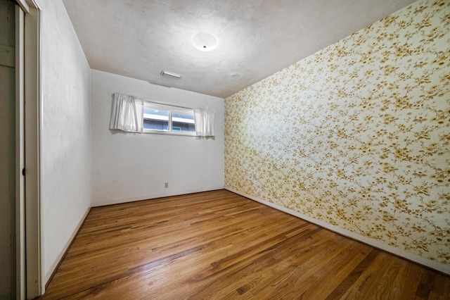 spare room featuring wood-type flooring