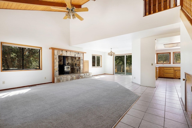 unfurnished living room featuring high vaulted ceiling, a stone fireplace, wooden ceiling, ceiling fan, and light tile patterned floors