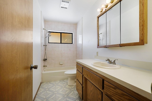 full bathroom with tile patterned floors, vanity, tiled shower / bath combo, and toilet