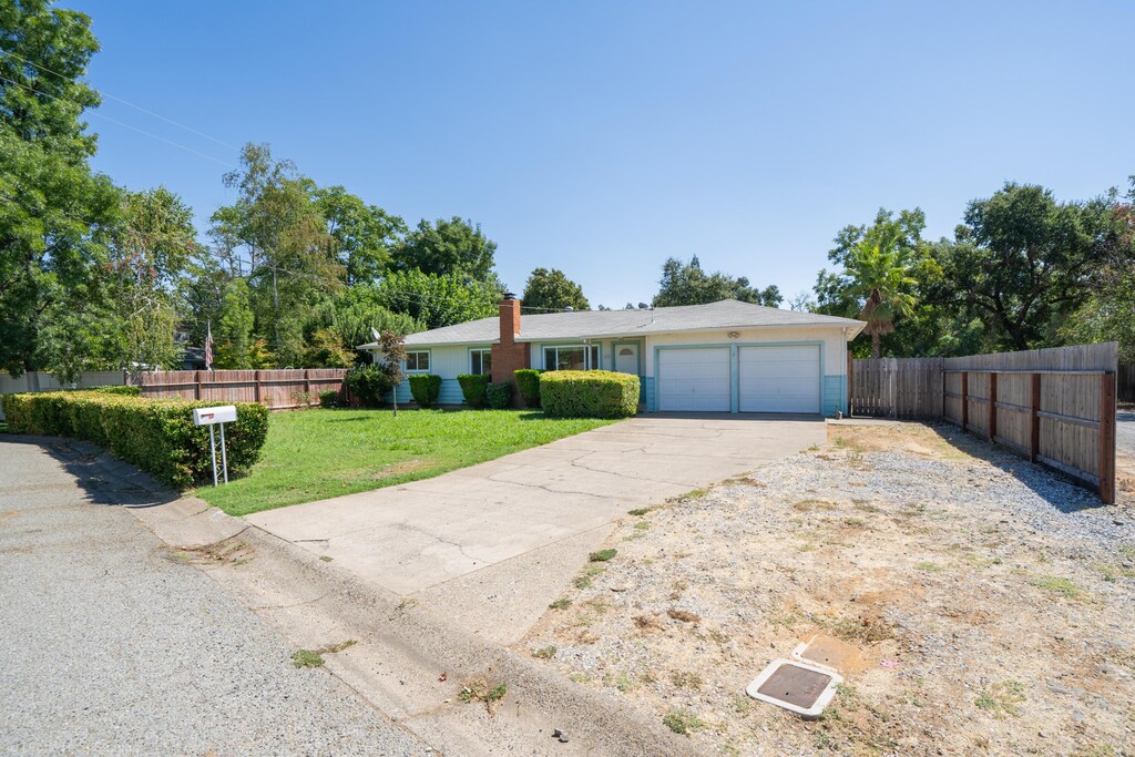 single story home featuring a front yard and a garage