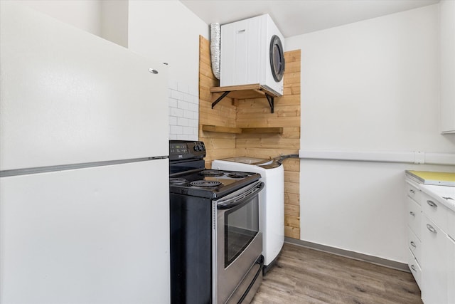 kitchen featuring white refrigerator, white cabinetry, wood-type flooring, and stainless steel range with electric cooktop