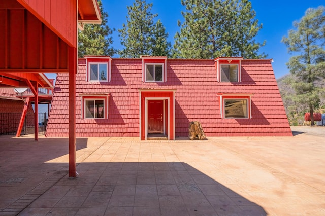 exterior space featuring mansard roof, a patio, and a tiled roof