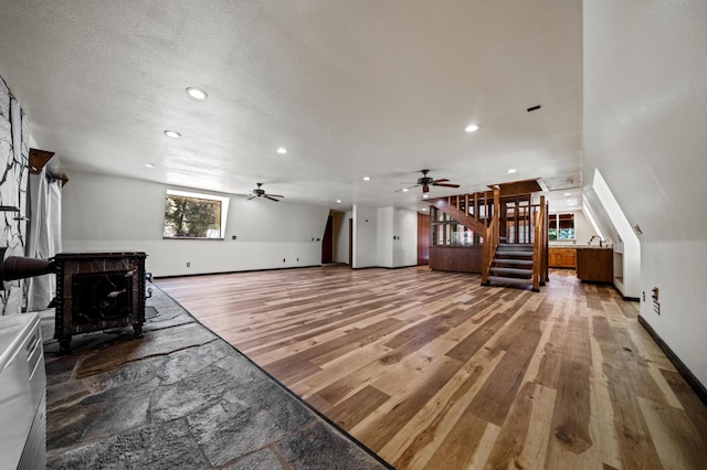 living room with ceiling fan, a textured ceiling, and hardwood / wood-style flooring