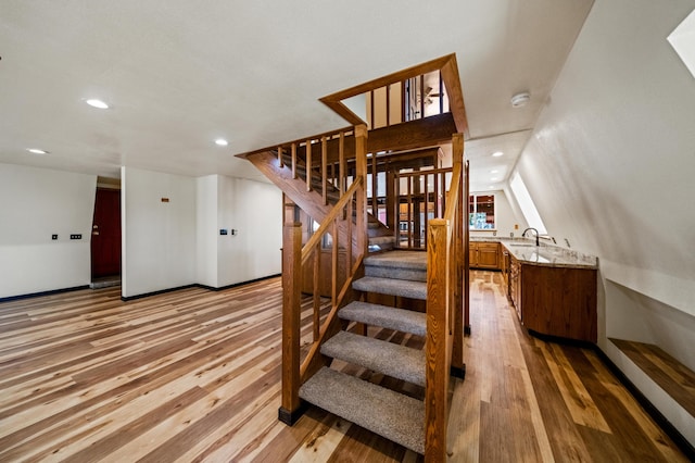 stairway with sink and light wood-type flooring