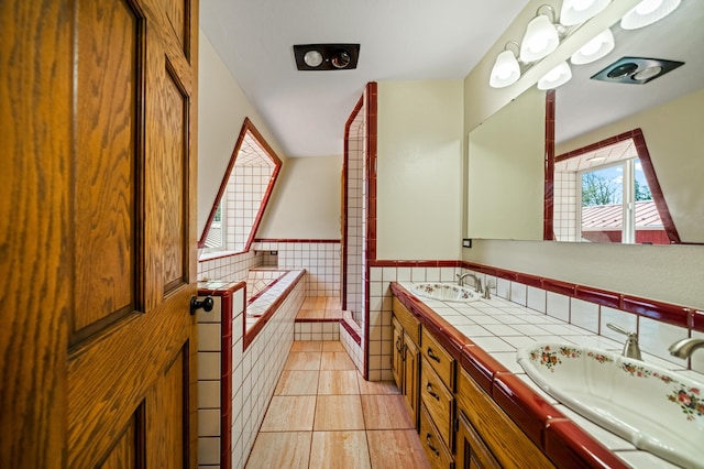 full bath featuring tile patterned floors, tile walls, a sink, and wainscoting