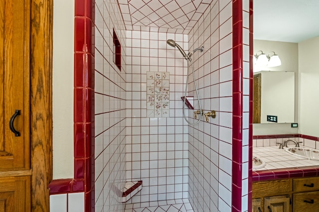 bathroom featuring a tile shower and vanity