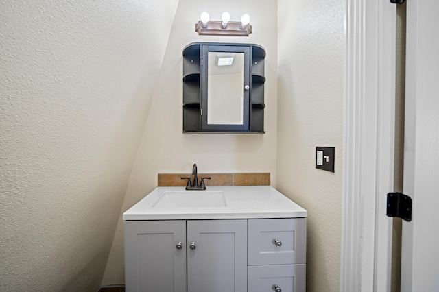 bathroom featuring a textured wall and vanity