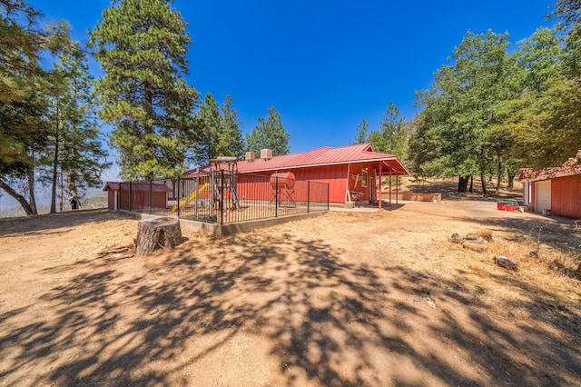 rear view of house with metal roof and an outdoor structure