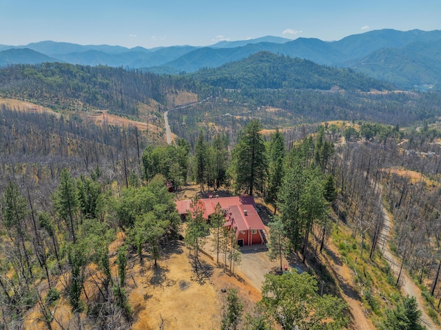 birds eye view of property featuring a mountain view and a wooded view