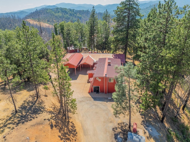 drone / aerial view featuring a mountain view and a view of trees