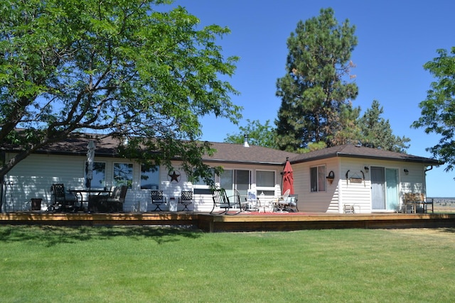 rear view of house with a deck and a yard