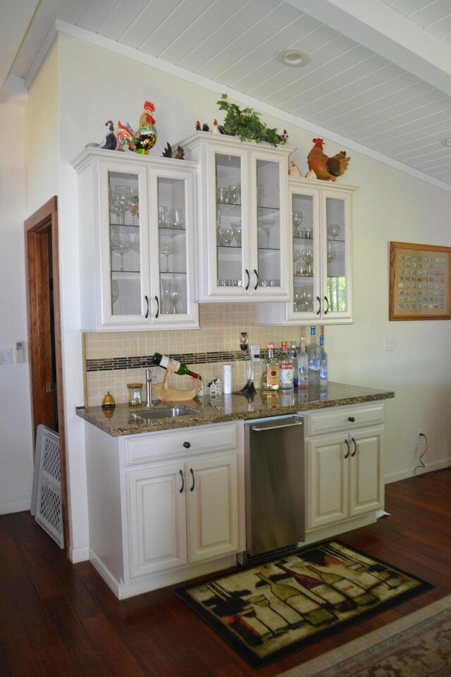 bar featuring dark hardwood / wood-style floors, beam ceiling, dishwasher, dark stone countertops, and backsplash