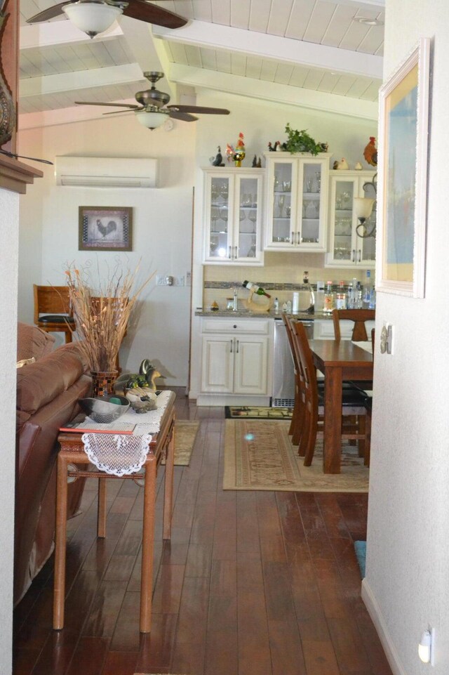 kitchen with dark hardwood / wood-style flooring, a wall unit AC, white cabinets, ceiling fan, and lofted ceiling with beams