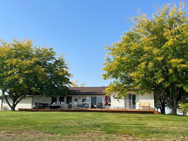 view of front of home with a wooden deck and a front lawn