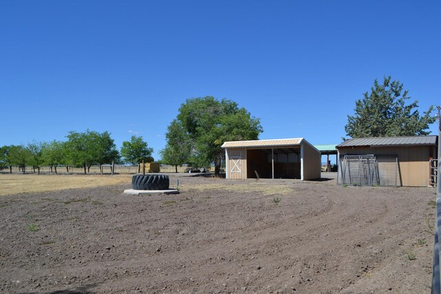 view of yard featuring a rural view and an outdoor structure