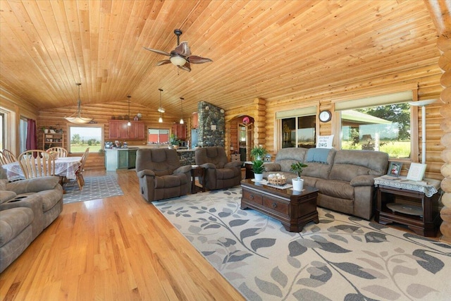 living room with ceiling fan, rustic walls, and light hardwood / wood-style floors