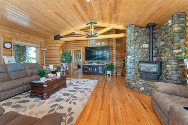 living room featuring lofted ceiling, light hardwood / wood-style floors, log walls, wooden ceiling, and a wood stove