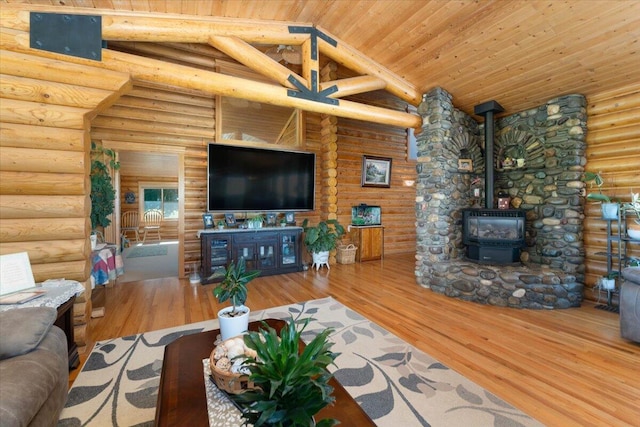 living room with log walls, a wood stove, light wood-type flooring, and wooden ceiling