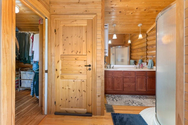 bathroom with rustic walls, wooden ceiling, vanity, and hardwood / wood-style floors