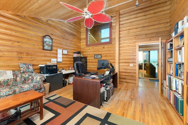 home office with wood ceiling, ceiling fan, high vaulted ceiling, rustic walls, and light wood-type flooring