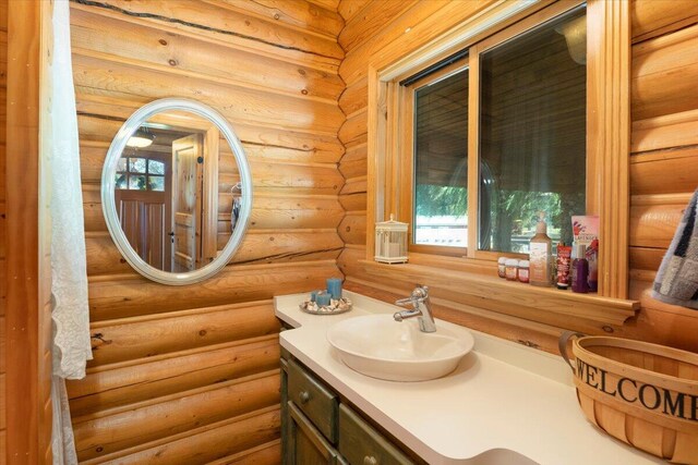 bathroom featuring rustic walls and vanity