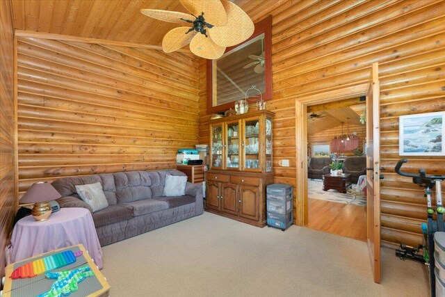 carpeted living room with high vaulted ceiling, rustic walls, ceiling fan, and wooden ceiling