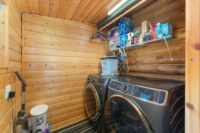 laundry room with wooden ceiling and washer and clothes dryer