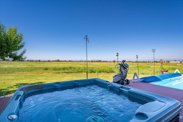 view of swimming pool with a rural view and an outdoor hot tub