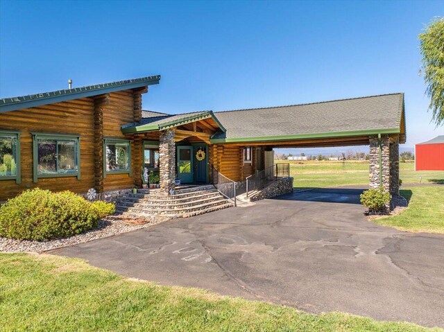 log cabin with a carport and a front lawn