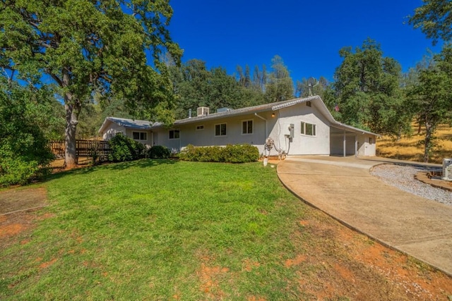 rear view of property featuring a lawn and a carport