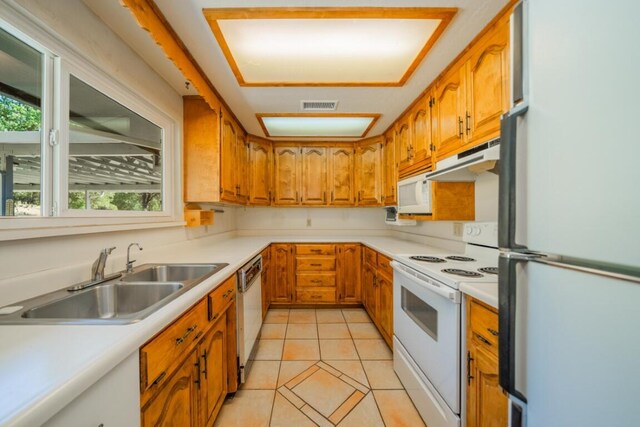 kitchen featuring sink, light tile patterned floors, and white appliances