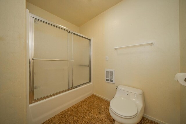 bathroom featuring vaulted ceiling, toilet, bath / shower combo with glass door, and heating unit