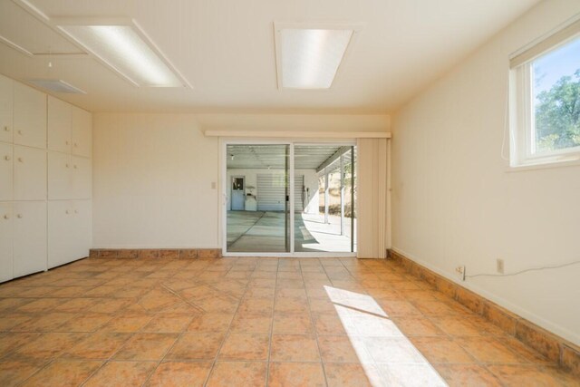 unfurnished room featuring a wealth of natural light and light tile patterned floors