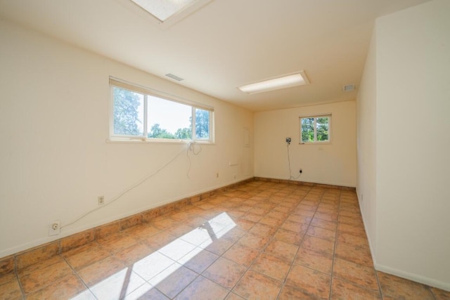 tiled empty room featuring a healthy amount of sunlight