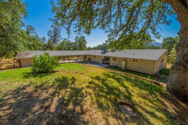 rear view of house with a yard and a patio