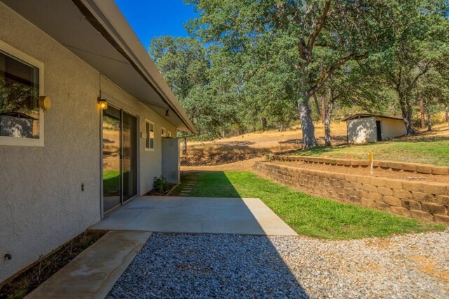 view of yard with a storage unit and a patio area