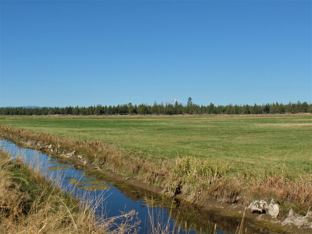 view of landscape with a rural view and a water view