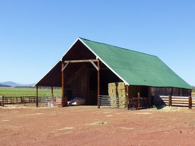 view of horse barn featuring a rural view and an outdoor structure