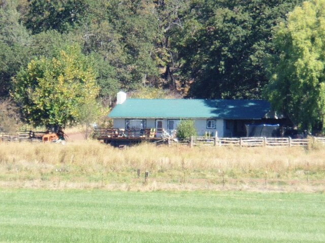 exterior space with a front lawn, a rural view, and a wooden deck