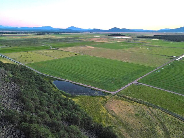 aerial view at dusk featuring a rural view and a mountain view