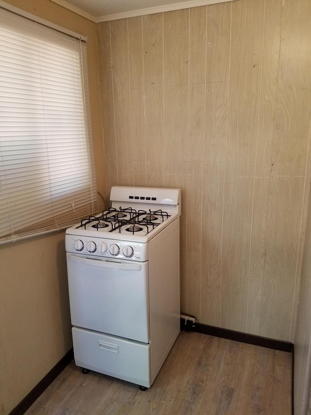 kitchen with white range with gas stovetop and hardwood / wood-style flooring